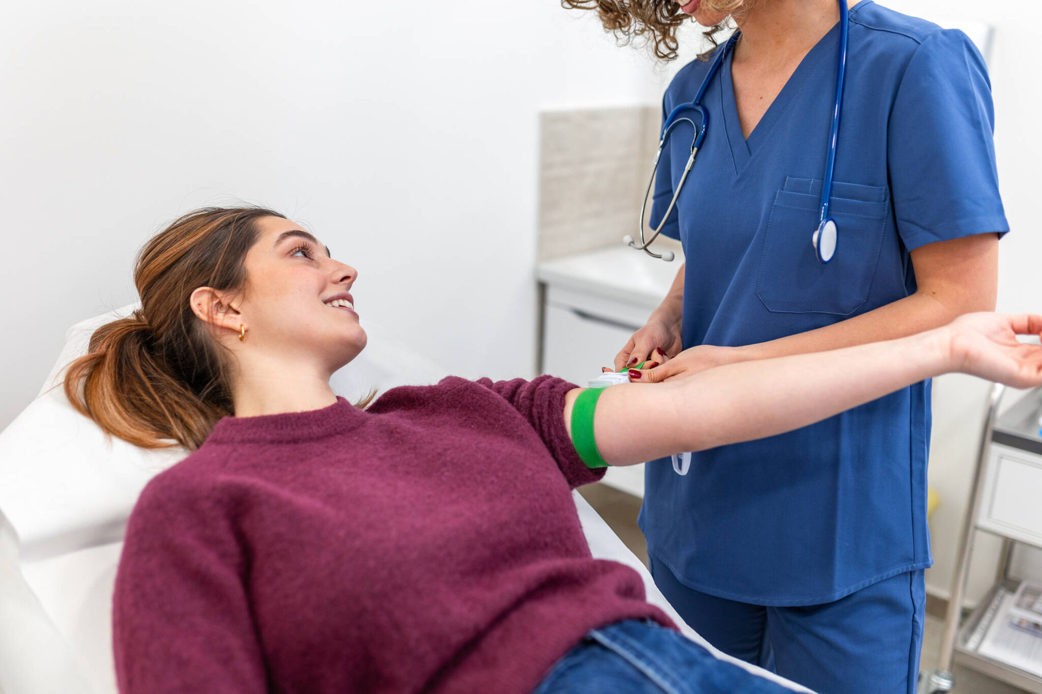 Woman having a blood test while talking to a healthcare professional.