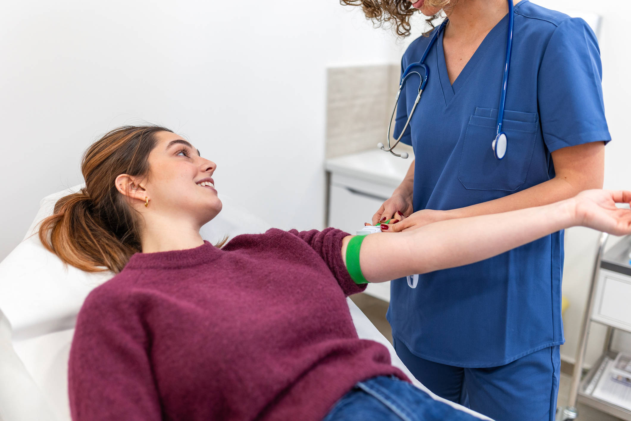 Woman having a blood test while talking to a healthcare professional.